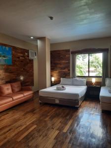 曼巴豪Mabini Hotel的一间大卧室,配有一张床和一张沙发