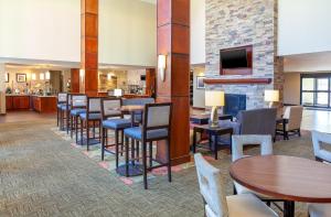 丹佛Staybridge Suites Denver - Central Park, an IHG Hotel的一间带桌椅和壁炉的餐厅