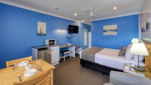 扬Colonial Motel & Apartments的酒店客房,设有床铺和蓝色的墙壁