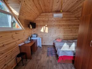 Krasnaya SlobodkaШафран的小木屋内的卧室配有1张床和书桌