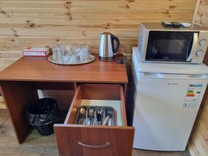Krasnaya SlobodkaШафран的一张桌子、一台微波炉和一台带抽屉的冰箱