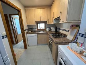 贝尼多姆Apartamento Paraiso Lido的厨房配有木制橱柜和炉灶烤箱。