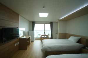 济州市The Beach Pension的酒店客房设有两张床和一台平面电视。