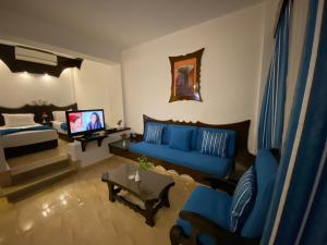 沙姆沙伊赫Aida Hotel Sharm El Sheikh的客厅配有蓝色的沙发和电视