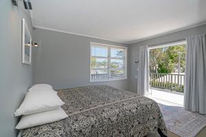 怀蒂昂格Rooftops Accommodation的一间卧室设有一张床和一个大窗户