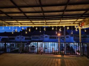 山打根Sweethome Homestay Sandakan的客房设有带灯和围栏的阳台。