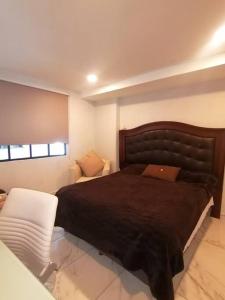 墨西哥城Apartamento cerca de Centro CitiBanamex的一间卧室配有一张大床和一把椅子
