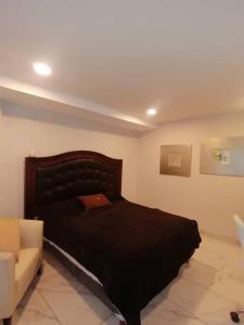 墨西哥城Apartamento cerca de Centro CitiBanamex的一间卧室配有一张黑色的床和一张沙发