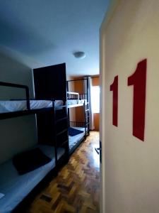 圣保罗Soul Hostel Av Paulista Bela Vista 2的一间设有双层床的客房,墙上有数个数字