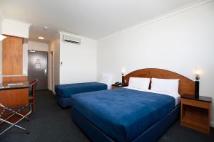 珀斯珀斯格蕾特南部酒店的酒店客房配有一张床、一张书桌、一张床和一张书桌。
