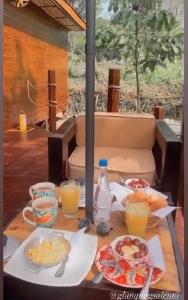 萨兰托Glamping Salento con jacuzzi climatizado的餐桌上放有食物和橙汁