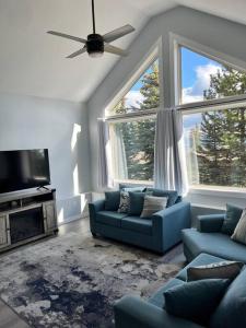 大白山Bearcub Chalet的客厅配有2张蓝色沙发和2扇大窗户