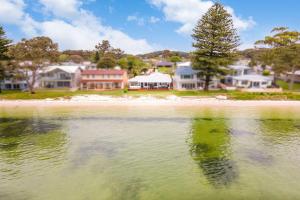 萨拉曼德湾Beached Inn Spacious beach front house的水体,有房子的背景