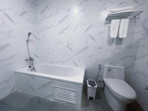 南奔GRAND PA Hotel&Resort Lamphun Chiang Mai的白色的浴室设有卫生间和浴缸。