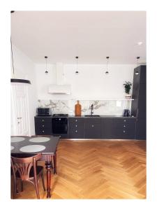维尔纽斯Garden appartament in a city center的厨房配有黑色橱柜和桌椅