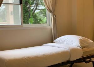 拉廊W house Ranong 2bedroom villa 8/9的一张位于带窗户的房间的床