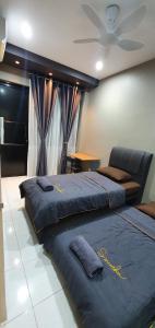Kota SamarahanRegalia Apartment B-3-1 Kota Samarahan的一间卧室配有两张床和吊扇