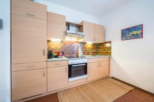 拉纳Apartement Oase的厨房配有木制橱柜和炉灶烤箱。