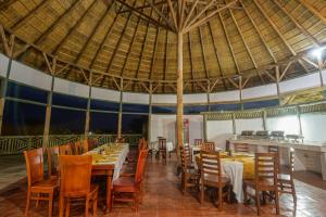 AruaTilenga Safari Lodge的一间带桌椅和大伞的餐厅