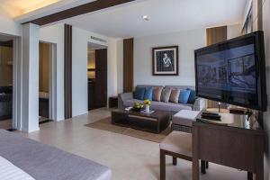 攀瓦海滩Cape Panwa Hotel Phuket的带沙发和电视的客厅