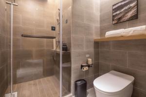 南通南通金沙亚朵酒店的一间带卫生间和玻璃淋浴间的浴室