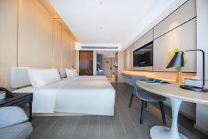中山中山小榄亚朵酒店的酒店客房设有一张大床和一张书桌。