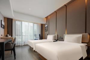 晋城晋城泽州路亚朵酒店的酒店客房配有两张床和一张书桌