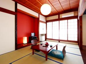 南砺富山県 よしのや旅館的客厅设有红色的墙壁和桌椅