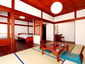 南砺富山県 よしのや旅館的客厅配有桌子和床。