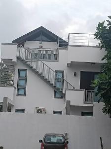 帕讷杜勒Villa Suyara Rooftop,,,的停在大楼前的带楼梯的停车场
