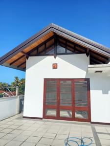 帕讷杜勒Villa Suyara Rooftop,,,的白色的建筑,有红色的车库门