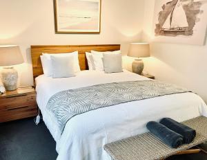 仙女港临水公寓的一间卧室配有一张带两盏灯的大型白色床。