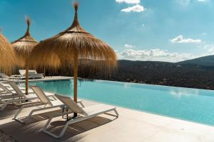 莫内斯特里奥Hoteles Desconecta2的一个带椅子和稻草遮阳伞的游泳池