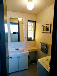 东京Homestay Intimo Amigo的浴室配有盥洗盆、镜子和浴缸
