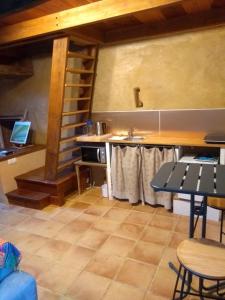 LopérecChaleureuse maisonnette的厨房配有桌子和台面上的笔记本电脑