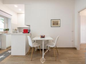 奥里斯塔诺Casa Aura - City Centre的白色的厨房配有白色的桌子和椅子