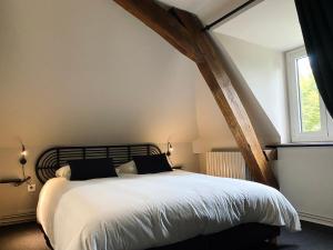 Bonneuil-les-EauxDomaine de Bonneuil的卧室配有一张带白色床单的大床和窗户。