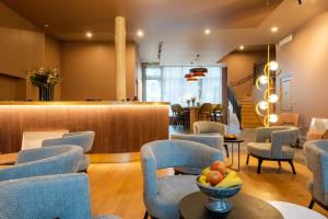 翁弗勒尔L'Invitation au Voyage Hôtel- Espace Bien-être - Bar Lounge的一间设有蓝色椅子和柜台的等候室