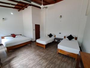 阿鲁甘湾Etnico Surf Resort的铺有木地板的客房内的两张床