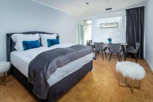 巴登-巴登Blue Sky Apart Center Baden-Baden的一间卧室配有一张大床和一张桌子及椅子