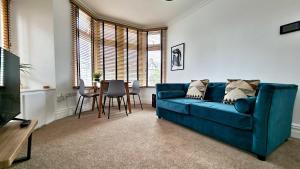 卡迪夫Thompson Apartments by Switchback Stays的客厅配有蓝色的沙发和桌子