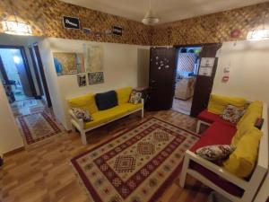 亚喀巴Hakaia Community的客厅配有黄色沙发和地毯。
