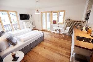 巴特维塞Apartmenthaus am Tegernsee - Studios mit Küchenzeile und mit Bus erreichbar的一间卧室配有一张大床和一张桌椅