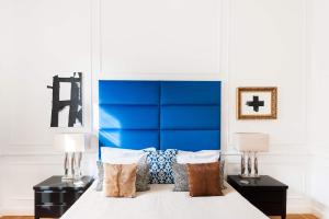 布达佩斯百老汇公寓的一间卧室配有蓝色床头板和一张带枕头的床