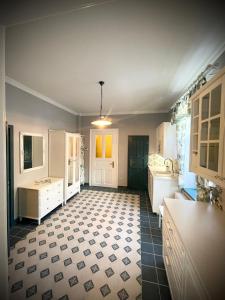 捷克克鲁姆洛夫TGM Apartments的厨房配有白色橱柜和黑白瓷砖地板。