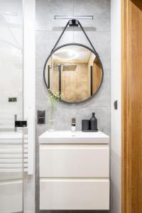 扎科帕内Apartamenty Harenda Zakopane的浴室设有镜子和白色水槽
