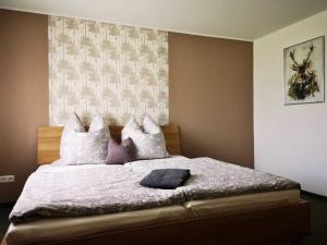 NardtLandhaus Kirchberg的卧室配有一张带白色和紫色枕头的大床