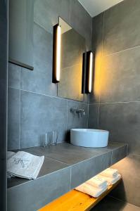 SívasO Mikros Kosmos Hotel Resort - Adults Only的一间带水槽和镜子的浴室