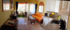 圣地亚哥港Apartamento Osos的客厅里带橙色沙发的厨房