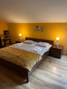 GelnicaPenzión Turzov的一间卧室配有一张大床、两张桌子和两盏灯。